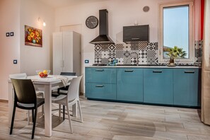 Una cocina con un armario blanco, una encimera azul y una ventana con vistas.