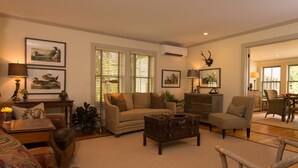 A spacious living room with a sofa, armchairs, a coffee table, and a dining area with a table and chairs. - A charming 1820's farmhouse (Woodstock)