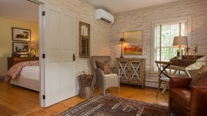 A room with a bed, a chair, a table, and a rug. - A charming 1820's farmhouse (Woodstock)