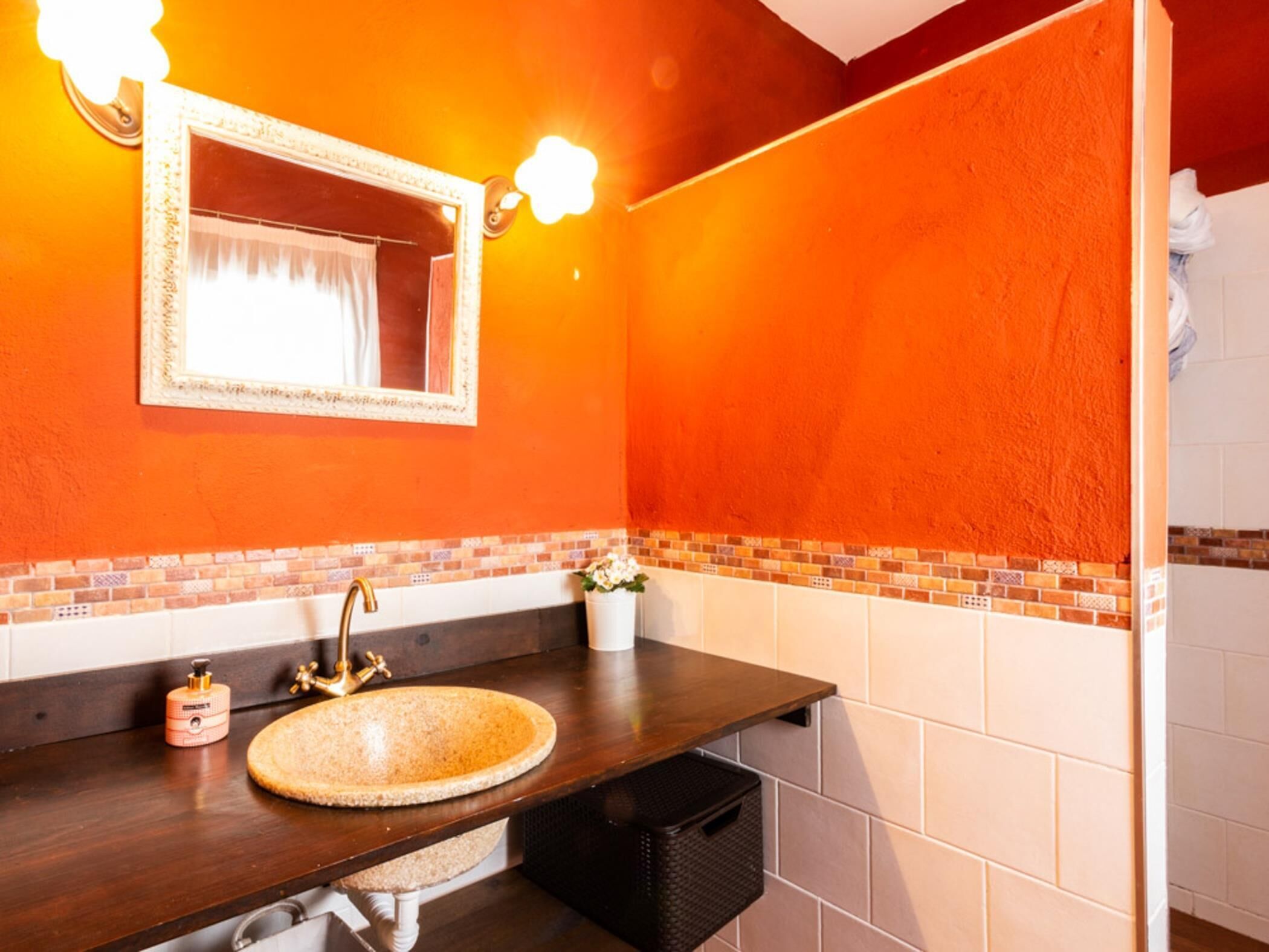 A bathroom with a round sink, a mirror, and a towel rack.