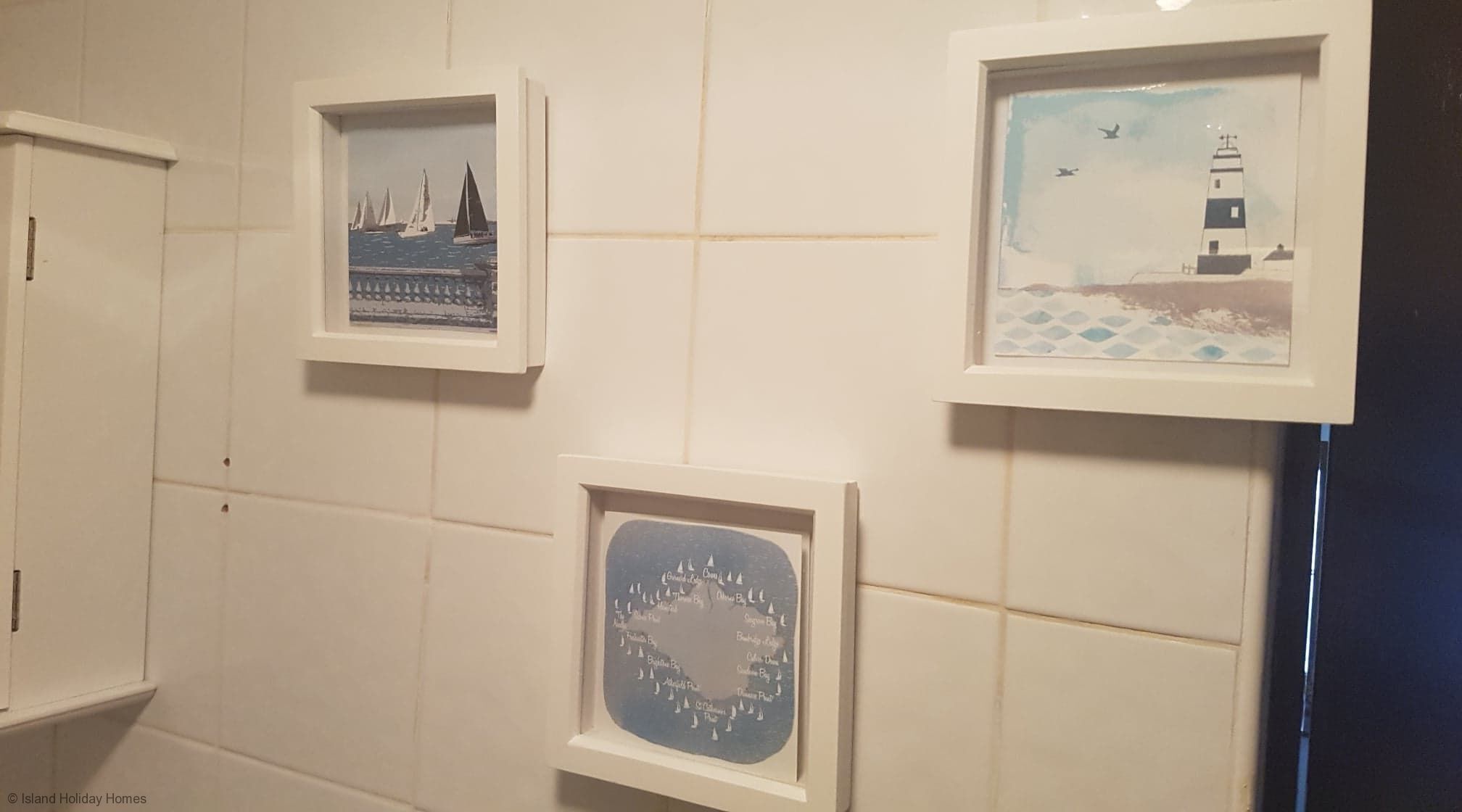 Drie kunstwerken in lijsten aan een muur.