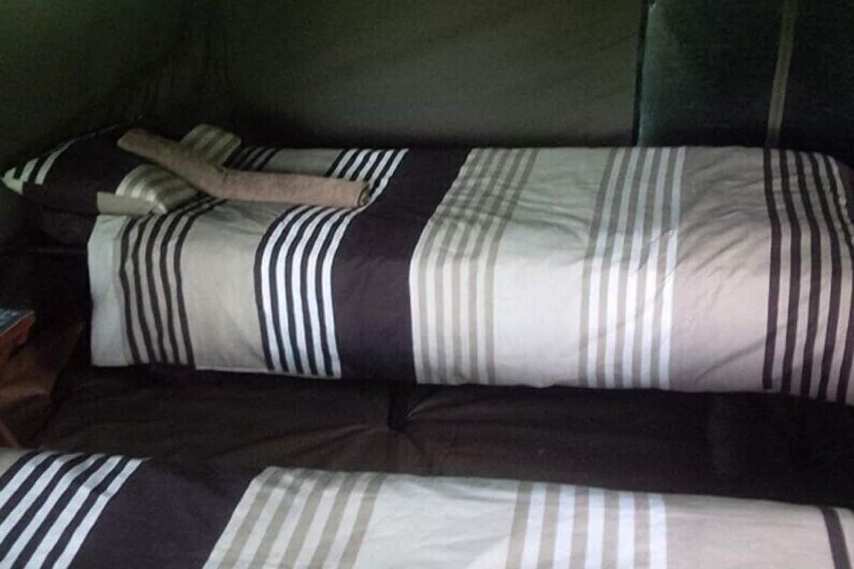 A bed with striped bedding and a wooden headboard.