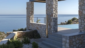 Estructura de piedra con una piscina y vistas al mar.