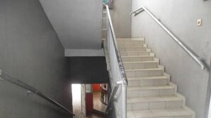 A staircase with a handrail, leading to an interior space with a tiled floor. - City Crown Hotels Limited (Port Harcourt)