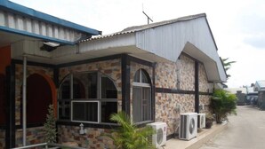 A building with a tiled facade, large windows, and air conditioning units. - City Crown Hotels Limited (Port Harcourt)