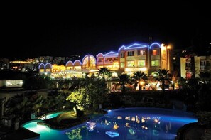 A hotel with multiple connected buildings, a swimming pool, and well-lit surroundings. - Phoenix Sun Hotel (Bodrum)