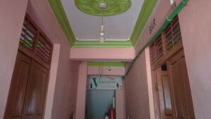 A hallway with a ceiling fan, a sign for 'Veroanto Hotel', and a 'BAR' sign on the wall. - Veroanto Hotel (Siaya)