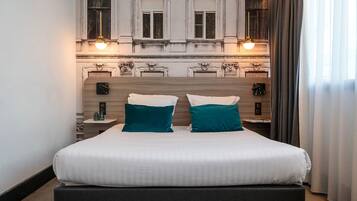 A hotel room with a large bed, two bedside tables, and a decorative headboard.