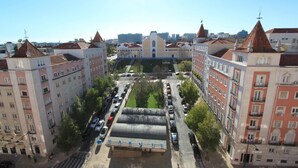A large building with a central courtyard, surrounded by multi-story buildings with red-tiled roofs. - Residencial Horizonte (Lisbon)