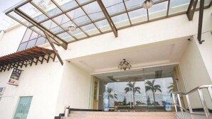 A hotel entrance with a glass door, a staircase leading up, and a metal railing. - Pelican Hotel (Batu Pahat)