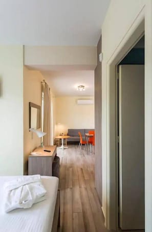 Een hotelkamer met een bed, een bureau, een stoel en een klein tafeltje.