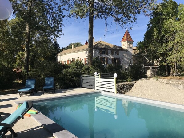 Relax by the serene pool surrounded by lush greenery and historic architecture.