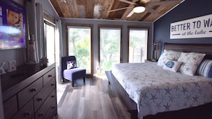 Quarto com cama, penteadeira, cadeira e ventilador de teto.