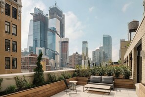 A rooftop terrace with a city view, outdoor seating, and planters. - Arlo Midtown (New York)