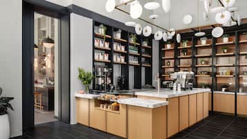 A modern kitchen with a central island, built-in shelves, and hanging pendant lights.