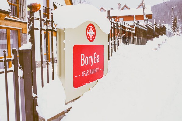 A sign for Borysa apartment with a red background and white text.