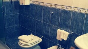 A bathroom with a toilet, bidet, and sink, all with white fixtures. - One-Bedroom Apartment (Otranto)