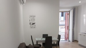 A modern living room with a brown sofa, dining table, and chairs. - Dormire a Napoli Centro Holiday House (Naples)