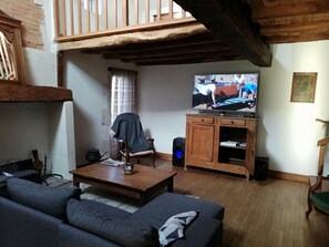 A living room with a wooden ceiling, a television, a wooden cabinet, and a sofa. - spacious house with garden above ground pool in small, quiet hamlet (Lisle)