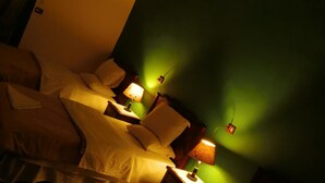 A hotel room with two beds, a desk, and a lamp. - New Hotel (Cairo)
