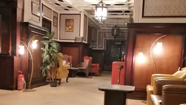 A lobby with a central coffee table, seating area with chairs, a potted plant, and framed pictures on the walls. - New Hotel (Cairo)