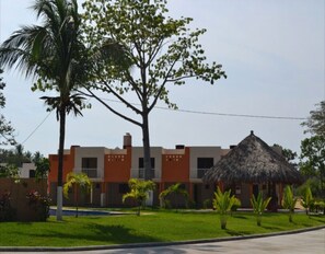 A hotel with a modern design, featuring a central building with a flat roof and a thatched-roof structure. - BEAUTIFUL HOUSE IN PUNTA DIAMOND ACAPULCO (Acapulco)