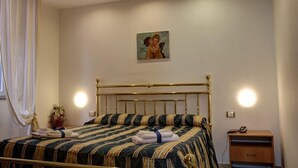 A bedroom with a bed, a nightstand, a lamp, and a painting on the wall. - Hotel Ambrogini (Montecatini Terme)