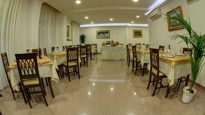 A spacious dining area with multiple tables and chairs, arranged in a U-shape. - Hotel Ambrogini (Montecatini Terme)