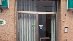 A building entrance with a glass door, a green sign, and a number '15' on the wall. - Hotel Ambrogini (Montecatini Terme)