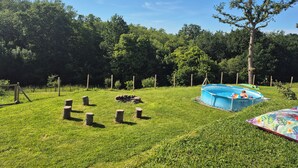 A backyard with a blue inflatable pool, a swing set, and a tree. - Top villa for families: pool, games, aperitifs, beaches and mountains nearby! (Villefranque)