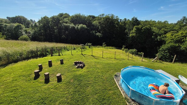 A backyard with a swimming pool, a wooden fence, and a grassy area. - Top villa for families: pool, games, aperitifs, beaches and mountains nearby! (Villefranque)