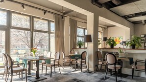 A modern dining area with large windows, a central table, and chairs.