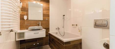 Un baño moderno con tocador de madera, una bañera y un inodoro.