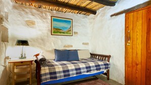 A cozy room with a bed, a wooden desk, and a chair.