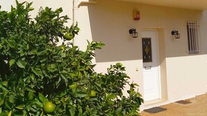 Un immeuble de deux étages doté d’un balcon, d’une petite fenêtre et d’une porte ornée d’un panneau de verre décoratif.
