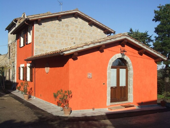 A two-story building with a stone facade and an orange exterior. - Red House/casa Rossa - Near Civita Di Bagnoregio (Bagnoregio)