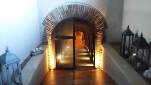 Um corredor com um arco de pedra que dá para um quarto.