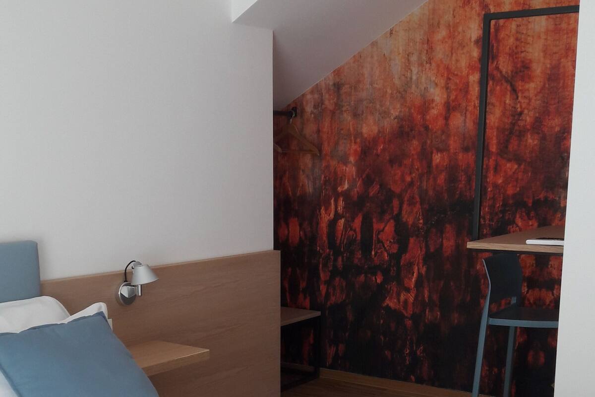A modern bedroom with a bed, a desk, and a chair.