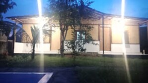 Un edificio con techo plano, un pequeño porche y un césped bien cuidado.