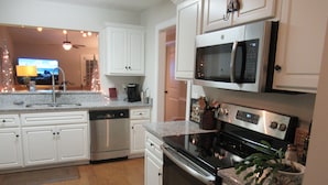 A modern kitchen with white cabinetry, stainless steel appliances, and a granite countertop. - THE " BOAT ANCHOR LOUNGE"  UPSCALE LUXURY (North Augusta)