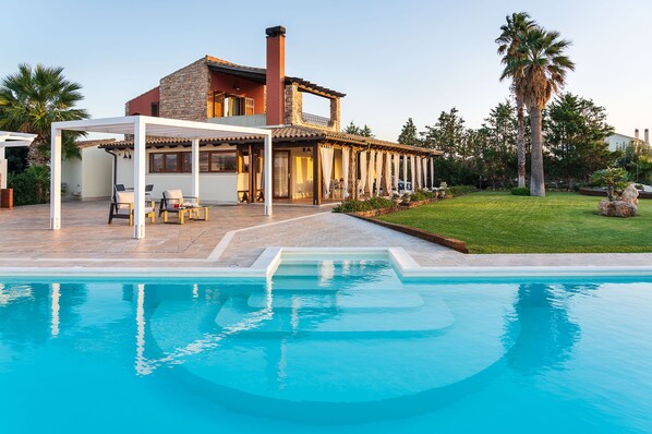 Una piscina al aire libre de temporada, sombrillas
