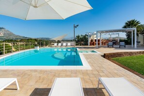 Una piscina al aire libre de temporada, sombrillas