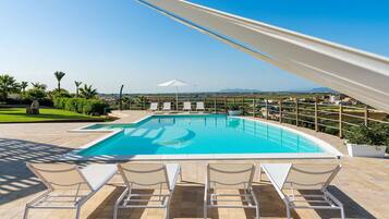 Relax by the pool surrounded by a scenic view and comfortable lounge chairs.