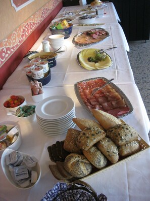 A buffet table with various food items and condiments.