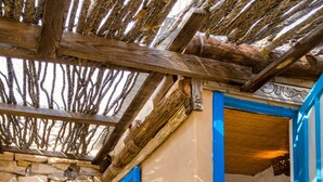 Ein Korridor mit Steinwänden und blauen Türen zu einem Badezimmer.