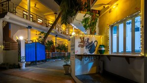 Un espace intérieur à plusieurs niveaux, doté d’un escalier, de plantes en pot et d’un coin café.