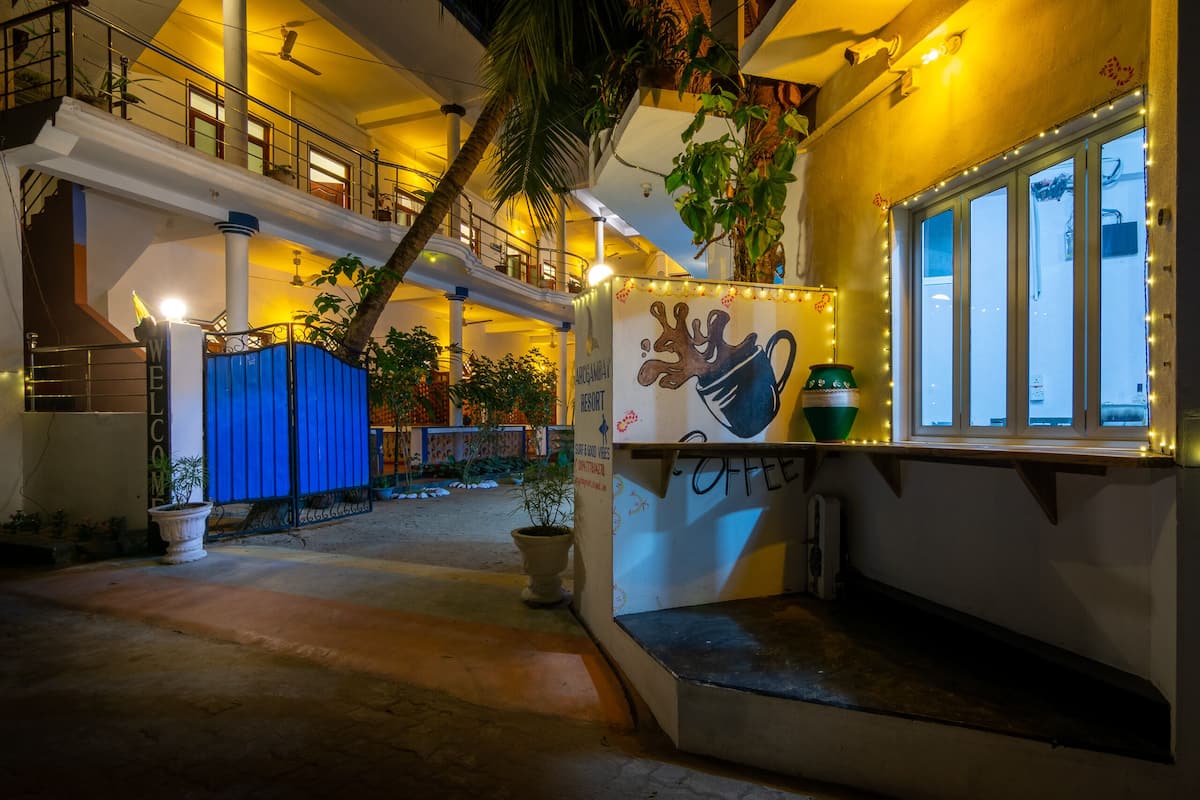 Un espacio interior de varios niveles con una escalera, plantas en macetas y una estación de café.