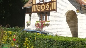 Una casa tradicional con entramado de madera, tejado inclinado y chimenea de ladrillo.