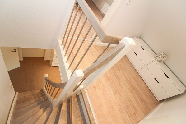 A wooden staircase with white railings leading to a landing. - Apartment Hafenbrise in Greetsiel for 4 people (Greetsiel)