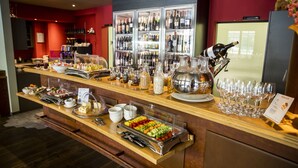 A buffet counter with various food items, a wine cooler, and a selection of wine glasses. - Gartenhaus by Ochsen Lenzburg (Lenzburg)